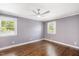 Bedroom features hardwood floors, neutral paint, ceiling fan, and plenty of natural light at 2120 Hillock Dr, Raleigh, NC 27612