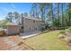 Back exterior of the home features a stone patio, privacy fence, and lush landscaping at 2120 Hillock Dr, Raleigh, NC 27612