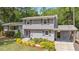 Charming home features a gray exterior, manicured lawn, lush landscaping, and eye-catching purple door at 2120 Hillock Dr, Raleigh, NC 27612