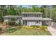 Charming home features a gray exterior, manicured lawn, lush landscaping, and eye-catching purple door at 2120 Hillock Dr, Raleigh, NC 27612