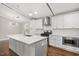 Bright kitchen boasts white cabinets, stainless steel appliances, quartz countertops, and a large island at 2120 Hillock Dr, Raleigh, NC 27612