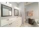 Bathroom featuring double sinks, modern lighting, and neutral tile at 2124 Castle Pines Dr, Raleigh, NC 27604
