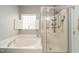 Bathroom with a soaking tub, a glass-enclosed shower, and a window providing natural light at 2124 Castle Pines Dr, Raleigh, NC 27604