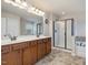 Large bathroom features double sinks, a tub, and a glass-doored shower at 2125 Toad Hollow Trl, Apex, NC 27502