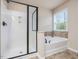 Bright bathroom with walk-in shower and a separate tub next to a window at 2125 Toad Hollow Trl, Apex, NC 27502