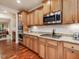 Well-lit kitchen features stainless steel appliances, granite countertops, and wooden cabinets at 2125 Toad Hollow Trl, Apex, NC 27502
