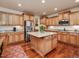Spacious kitchen featuring granite countertops, stainless steel appliances, central island, and hardwood floors at 2125 Toad Hollow Trl, Apex, NC 27502