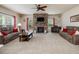 Comfortable living room with stone fireplace, large windows, plush seating, and a ceiling fan at 2125 Toad Hollow Trl, Apex, NC 27502