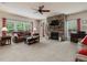 Bright living room with stone fireplace, large windows, plush seating, and a decorative ceiling fan at 2125 Toad Hollow Trl, Apex, NC 27502