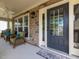 Cozy front porch featuring stone accents, wicker furniture, and ceiling fan perfect for outdoor relaxation at 2125 Toad Hollow Trl, Apex, NC 27502