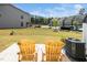 Backyard patio with wooden chairs and view of the lawn at 2129 Mars Hill Ln, Apex, NC 27502