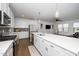 Spacious kitchen featuring a central island, stainless steel appliances, white cabinets, and a seamless transition to the living room at 2129 Mars Hill Ln, Apex, NC 27502