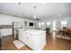 Open-concept kitchen with a large island, stainless steel appliances, white cabinets, and seamless flow to the living area at 2129 Mars Hill Ln, Apex, NC 27502