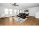 Spacious living room with hardwood floors, large windows, and a comfortable leather sofa at 2129 Mars Hill Ln, Apex, NC 27502