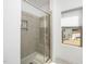 Modern tiled shower with glass door and built-in shelving in a well-lit bathroom at 2129 Mars Hill Ln, Apex, NC 27502