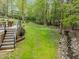 Backyard with a creek, landscaping, and stairs leading up to the deck at 213 Lewiston Ct, Cary, NC 27513