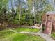Backyard featuring a wooden deck with outdoor seating, green grass, stepping stones, and wooded privacy at 213 Lewiston Ct, Cary, NC 27513