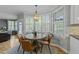 Bright breakfast nook features a round table, four chairs, and a window seat with large shuttered windows at 213 Lewiston Ct, Cary, NC 27513