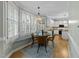 Bright breakfast nook leading to kitchen features a round table, four chairs, and a window seat with large shuttered windows at 213 Lewiston Ct, Cary, NC 27513