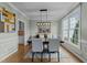 Elegant dining room featuring hardwood floors, large windows, and modern chandelier at 213 Lewiston Ct, Cary, NC 27513
