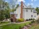 Charming two-story home with a brick chimney, wooden deck, stone path, and beautiful landscaping at 213 Lewiston Ct, Cary, NC 27513