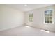 Sunlit bedroom with neutral carpet, two windows, and a fresh, clean aesthetic at 22 Lure Ct, Durham, NC 27713