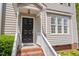 Close-up of the front door, showcasing the black door, white trim, and brick steps at 22 Lure Ct, Durham, NC 27713