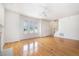 Open living room with hardwood floors, ceiling fan, and large windows providing ample light at 22 Lure Ct, Durham, NC 27713