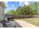 A large backyard with a concrete patio area, grill, and seating perfect for outdoor entertaining at 232 Vinewood Pl, Holly Springs, NC 27540