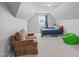 Attic bedroom featuring a comfortable sitting area, natural light, and neutral decor at 232 Vinewood Pl, Holly Springs, NC 27540
