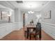 Traditional dining room with hardwood floors, wainscoting, and a view into the kitchen area at 232 Vinewood Pl, Holly Springs, NC 27540