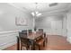 Traditional dining room with hardwood floors, wainscoting, and an elegant chandelier for stylish dining at 232 Vinewood Pl, Holly Springs, NC 27540