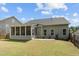 Back exterior view of a home with a screen porch, patio, and a spacious backyard at 232 Vinewood Pl, Holly Springs, NC 27540