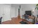 Hallway with hardwood floors, light gray walls, two doors, a gaming desk, and office chair at 232 Vinewood Pl, Holly Springs, NC 27540