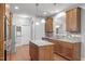Open kitchen with a granite island, hardwood floors, stainless steel appliances, and ample storage space at 232 Vinewood Pl, Holly Springs, NC 27540