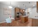 Modern kitchen with an island, stainless steel appliances, built-in oven, and wooden cabinets on hardwood floors at 232 Vinewood Pl, Holly Springs, NC 27540