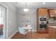 Modern kitchen with an island, stainless steel appliances, built-in oven, and wooden cabinets with breakfast nook at 232 Vinewood Pl, Holly Springs, NC 27540