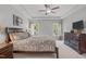 A spacious bedroom featuring two windows, a dresser, and neutral paint at 232 Vinewood Pl, Holly Springs, NC 27540