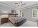 Relaxing main bedroom features a tray ceiling, a ceiling fan, and large windows at 232 Vinewood Pl, Holly Springs, NC 27540