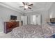 Spacious bedroom featuring a dark wood dresser, ceiling fan, and ensuite bathroom at 232 Vinewood Pl, Holly Springs, NC 27540