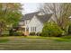 Expansive backyard featuring a well-maintained lawn, mature trees, and a wooden deck with a screened-in porch at 2404 Gillingham Dr, Apex, NC 27539