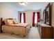 Bedroom featuring a wooden dresser, queen bed with floral bedding, and ample natural light at 2404 Gillingham Dr, Apex, NC 27539