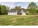 View of a light blue home featuring an attached garage and a detached garage on a large, well-maintained lawn at 2404 Gillingham Dr, Apex, NC 27539