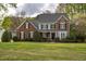 Charming two-story home with a manicured lawn, brick accents, and a welcoming front porch at 2404 Gillingham Dr, Apex, NC 27539