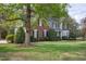Landscaped front yard featuring a beautiful two-story home with black shutters and mature trees at 2404 Gillingham Dr, Apex, NC 27539