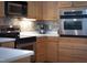 Bright kitchen featuring stainless steel appliances, tile backsplash, and light wood cabinetry at 2404 Gillingham Dr, Apex, NC 27539