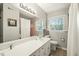 Clean bathroom with a large mirror, white vanity, and natural light from the window at 2415 Alpine Rd, Durham, NC 27707
