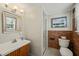 Well-lit bathroom featuring a classic vanity, a shower, and brick accents at 2415 Alpine Rd, Durham, NC 27707