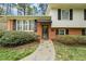Close-up of home's entrance featuring a brick facade, black shutters, and a stone pathway at 2415 Alpine Rd, Durham, NC 27707