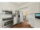 Well-lit kitchen featuring stainless steel appliances, white cabinetry, and hardwood floors at 2415 Alpine Rd, Durham, NC 27707